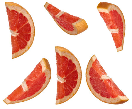 Several sliced ââred grapefruit wedges from different angles, placed on an isolated background.の写真素材