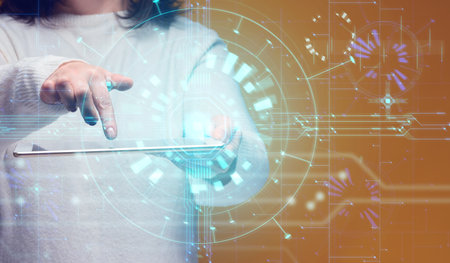 A woman holds a tablet, a projection of a glowing AI interface. In the foreground, her hand...