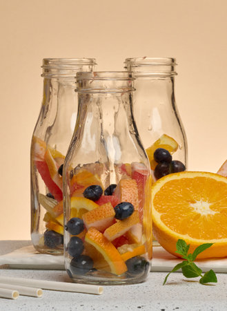 Glass bottles filled with citrus slices and blueberries