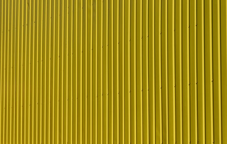 Bright texture of vertical metal siding painted yellow. Full frameの写真素材