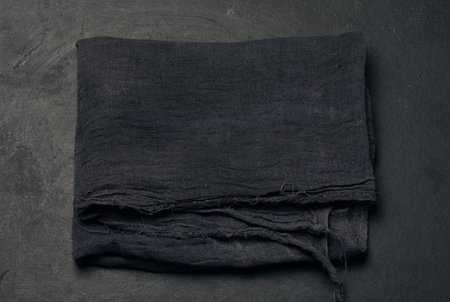 Folded black gauze napkin on black table, top viewの写真素材