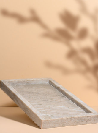 Empty marble rectangular food tray on beige background with shadowの写真素材