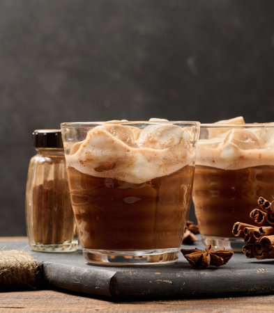Glasses of hot chocolate with fluffy marshmallows on a wooden table.の写真素材