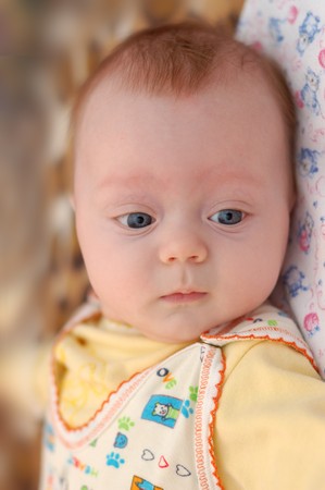Little 4-months with big blue eyes boy looking down