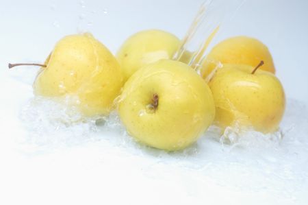 Yellow ripe apples under water splashの写真素材