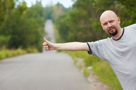 Bald-headed man hitching on roadの写真素材