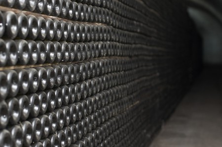 Tunnel with old aged wine in dusted bottles. Winemaking plant.の写真素材