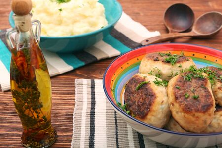 Fried savory tuna patties with potato in the bowl on wooden table