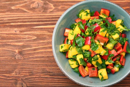 Mango salad with pepper and parsley in a bowlの写真素材