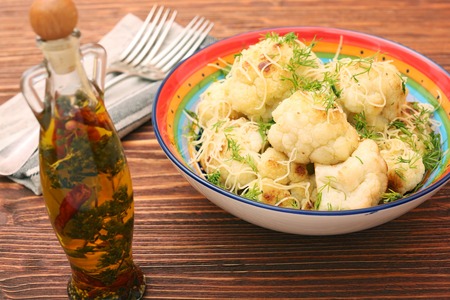 Fried cauliflower with cheese and greensの写真素材