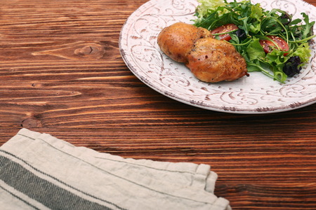 Smoked chicken leg with salad on wooden table