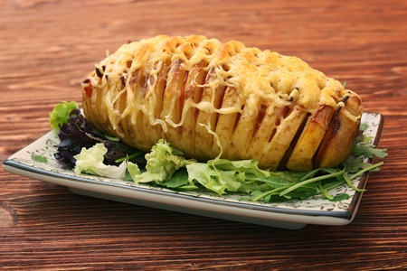 Sliced baked potatoes with cheese and baconの写真素材