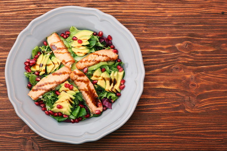 Salad with fried salmon, avocado and pomegranate seedsの写真素材