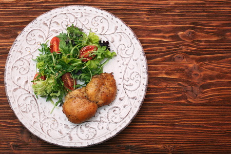 Smoked chicken leg with salad on wooden tableの写真素材