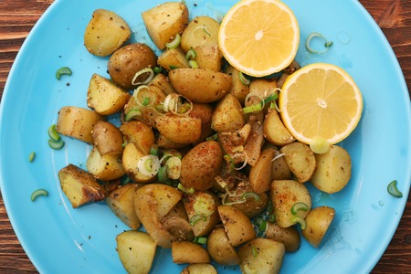 Baked potatoes with lemon on wooden backgroundの写真素材