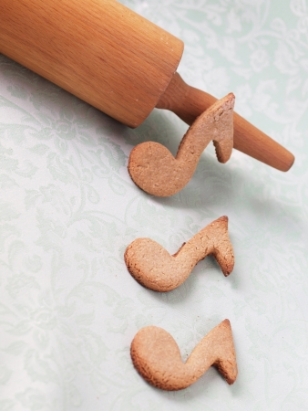 Oatmeal cookies shaped as notes on a green backgroundの写真素材