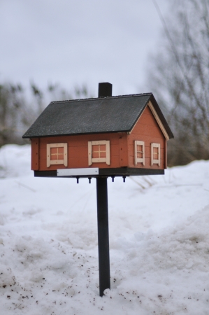 Mailbox shaped as house standing in the snowの写真素材