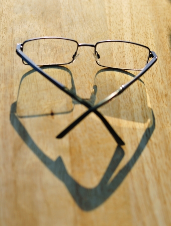 Glasses laying on sunlit wooden tableの写真素材