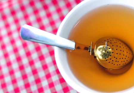 A cup of tea with a brewing spoonの写真素材