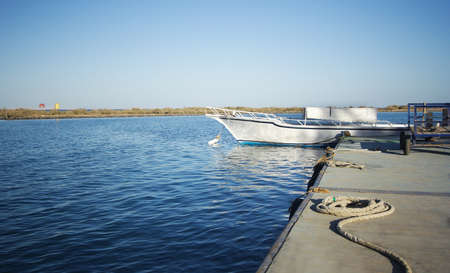 white boat on an anchor in harborの写真素材