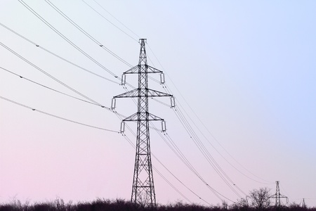electricity pylon with many cables on blue and purple skyの写真素材