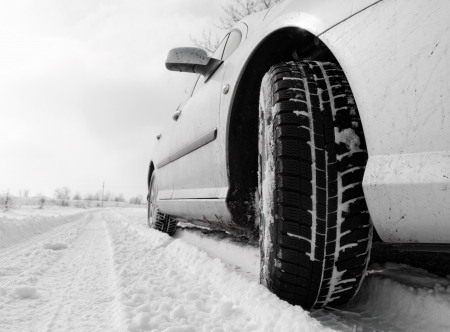 Close up of a cars tires on a snowy roadの写真素材