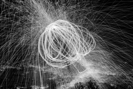 Showers of hot glowing sparks from spinning steel wool.の写真素材