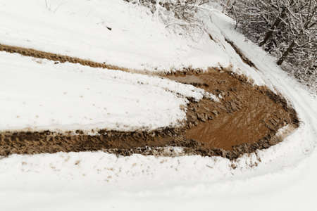 Traces from wheels of the car on muddy snowの写真素材
