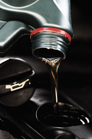 Fresh oil being poured during an oil change to a carの写真素材