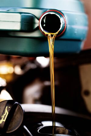 Fresh oil being poured during an oil change to a carの写真素材