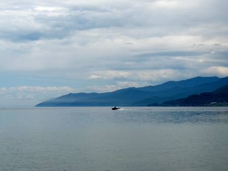 Motor boat in the distance on Lake Baikal on a cloudy summer dayの写真素材