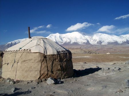 yurt and snow capped mountainsの写真素材