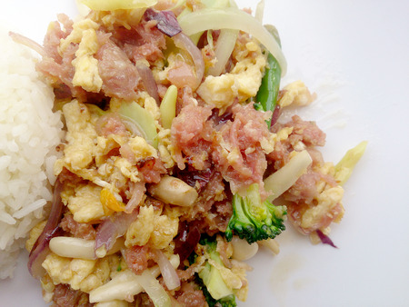 Stir-fried egg with Sour sausage in banana leaf, pork, shredded and salted, bound tighly with banana leaves & thai jasmin rice in white dishの写真素材