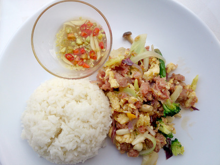 Stir-fried egg with Sour sausage in banana leaf, pork, shredded and salted, bound tighly with banana leaves & thai jasmin rice in white dishの写真素材
