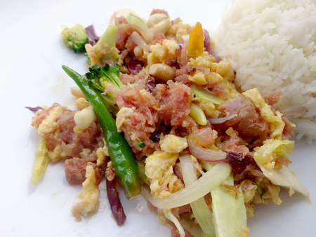 Stir-fried egg with Sour sausage in banana leaf, pork, shredded and salted, bound tighly with banana leaves & thai jasmin rice in white dishの写真素材