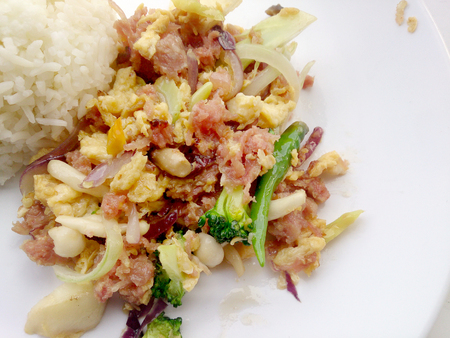 Stir-fried egg with Sour sausage in banana leaf, pork, shredded and salted, bound tighly with banana leaves & thai jasmin rice in white dishの写真素材