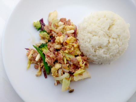 Stir-fried egg with Sour sausage in banana leaf, pork, shredded and salted, bound tighly with banana leaves & thai jasmin rice in white dishの写真素材