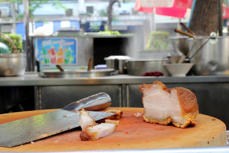 Oriental Roast Pork Belly on wooden chopping board with market womenの写真素材