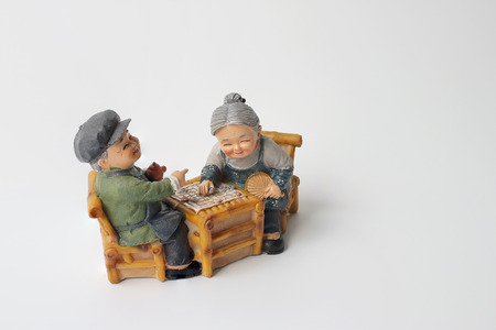 lovely grandparent doll siting rocking bamboo chair with playing checkerboard.の写真素材