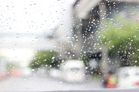 A very rare rainy day in Bangkok, Thailand with van and people as seen through car windows with rain drops visible on the window.の写真素材