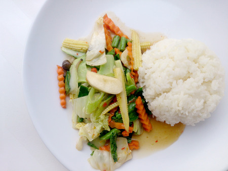 Vegetarian stir fry with thai jasmine rice on white dish, healthy foodの写真素材