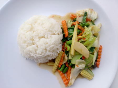 Vegetarian stir fry with thai jasmine rice on white dish, healthy foodの写真素材