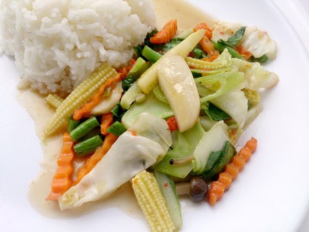 Vegetarian stir fry with thai jasmine rice on white dish, healthy foodの写真素材