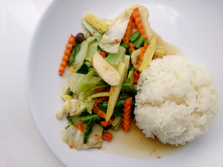 Vegetarian stir fry with thai jasmine rice on white dish, healthy foodの写真素材