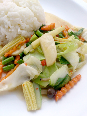 Vegetarian stir fry with thai jasmine rice on white dish, healthy foodの写真素材