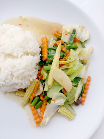 Vegetarian stir fry with thai jasmine rice on white dish, healthy foodの写真素材