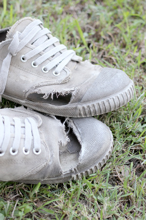 Dirty old shoes on grass backgroundの写真素材