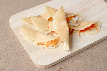 Thai pancake it is delicious snacks on wood background , Kind of Thai sweetmeat or Kanom Buang - Thai Style Crispy Tart or Thai sweetmeat with wood cutting board on wood backgroundの写真素材