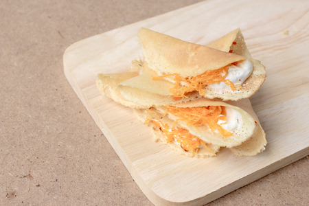 Thai pancake it is delicious snacks on wood background , Kind of Thai sweetmeat or Kanom Buang - Thai Style Crispy Tart or Thai sweetmeat with wood cutting board on wood backgroundの写真素材