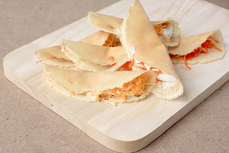 Thai pancake it is delicious snacks on wood background , Kind of Thai sweetmeat or Kanom Buang - Thai Style Crispy Tart or Thai sweetmeat with wood cutting board on wood backgroundの写真素材